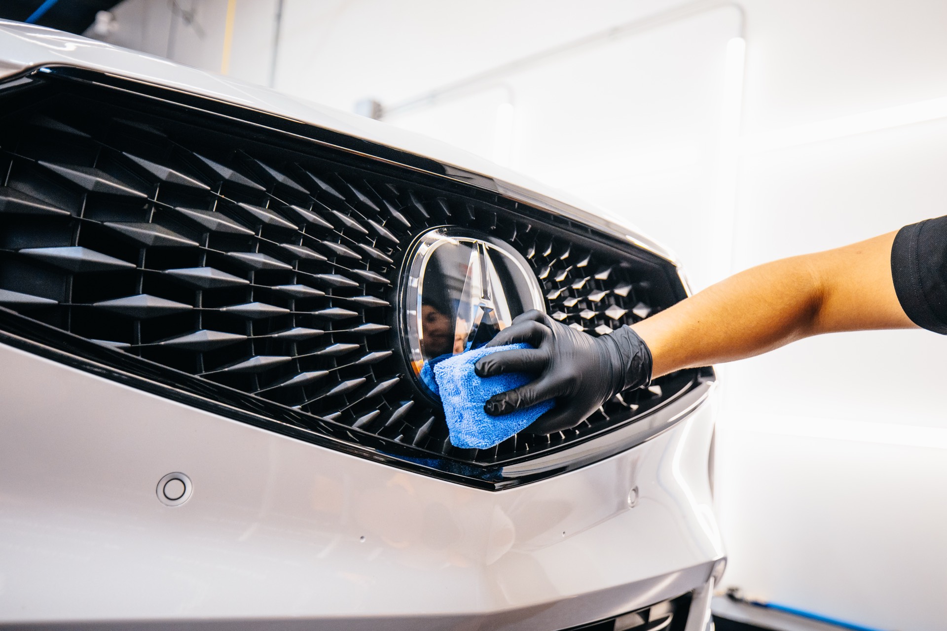 Detail work on a vehicle grille during ceramic coating prep